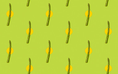 Seamless pattern with fresh asparagus on green table background.