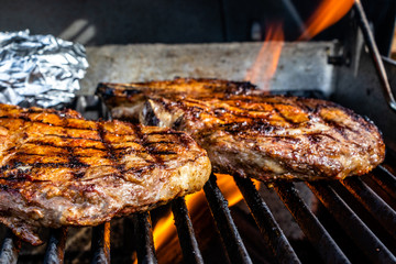 Fire licking the steaks on the grill. Calgary, Alberta, Canada
