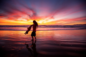 Fototapeta premium mother and son having fun at sunset on the beach