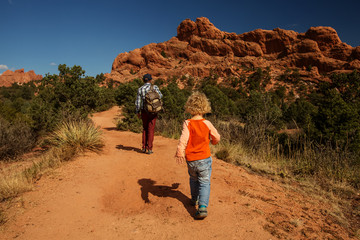 A man with his son are hiking in mountains