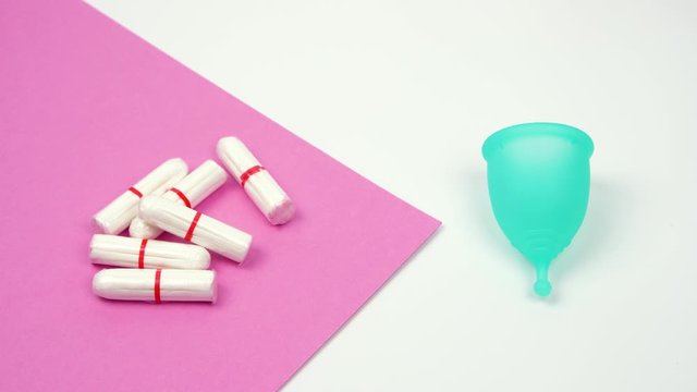 the female hand chooses the menstrual cup as an alternative to hygienic tampons, personal care products during menstruation period time close-up
