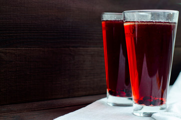 Glass with berry compote on a wooden table.