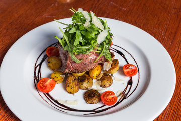 Grilled steak with fresh tomatoes and garlics.