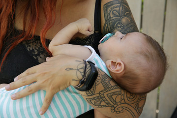 Close-up. Cute newborn baby in the arms of mother. Happy family, motherhood, parenting, people and...