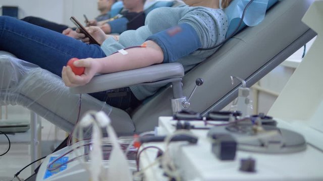 A person uses medical equipment while preparing to donate blood.