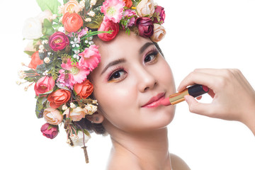 Fototapeta premium Portrait of beautiful young asian woman with flowers and skin care, Young girl applying cosmetic.