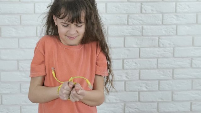 Child electronic addiction. Little girl with her hands tied with a wire from a gadget. Addiction to gadgets.