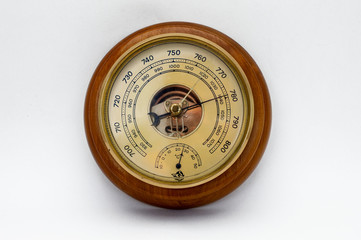 Aneroid barometer in a wooden case on a white background.