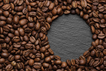 roasted coffee beans on stone black background. top view with space for text