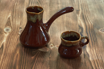 cup with cezve on a wooden table