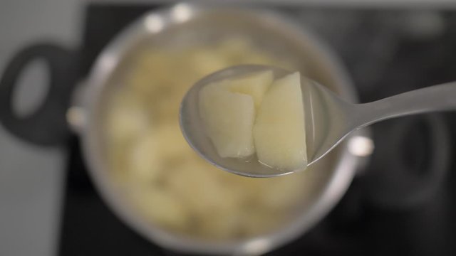sliced ​​boiled potatoes in a tablespoon on a background of a potato pan. 4k. 4k video