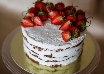 the beautiful cake with strawberries and cream on table