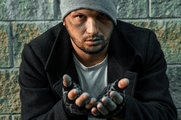 A man, homeless, a person asks for alms on the street with a Help sign. concept of homelessness,...