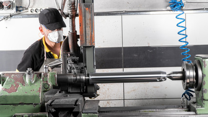  factory employee engaged in the production of pin bushing on the lathe in the factory