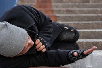 A man, homeless, a person asks for alms on the street with a Help sign. concept of homelessness, social problem, drug addict, poverty, despair.