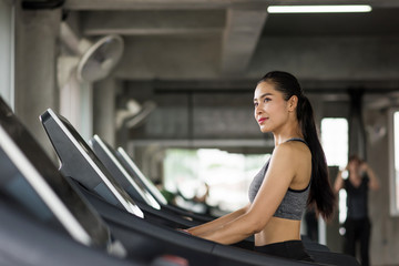 Fototapeta na wymiar Asian woman run on treadmill in gym