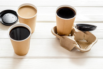 Black coffee and coffee with milk to-go on white wooden background