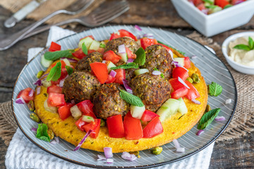 Curried chickpea cake with pistachio lamb meatballs and tomato sambal