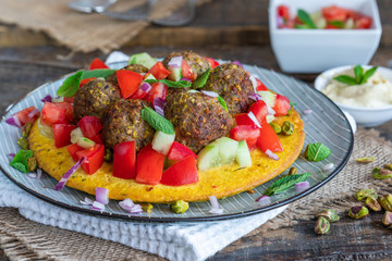 Curried chickpea cake with pistachio lamb meatballs and tomato sambal