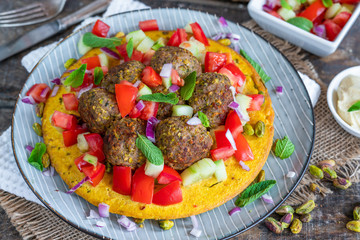 Curried chickpea cake with pistachio lamb meatballs and tomato sambal