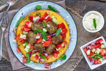 Curried chickpea cake with pistachio lamb meatballs and tomato sambal - overhead view