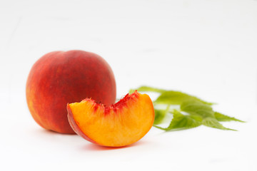 Delicious and juicy peach with leaves on white background. Healthy summer fruit.
