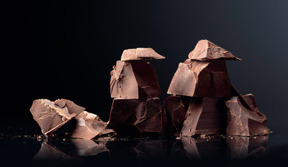 Pieces of dark chocolate on a dark background.