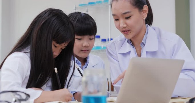 Teacher and students research information in computer for science project. education, science and children concept.