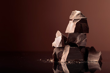 Pieces of dark chocolate on a dark background.