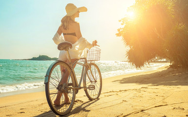 Happiness woman traveler with her bicycle rides on sea coastline