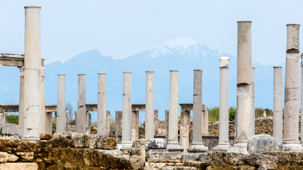 Fototapeta premium Marble columns on a background of mountains in the Ancient city of Perge near Antalya, Turkey