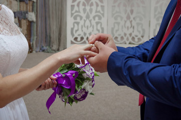 Marriage hands with rings. The bride puts a ring on the finger of the groom during the wedding ceremony. The bride and groom exchange rings in wedding day. Photo closeup