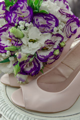 Wonderful bridal bouquet and bride's shoes. Wedding shoes of the bride with a bouquet of roses and other flowers.