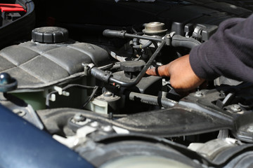 someone under the hood fixing a car