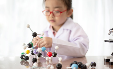 Young scientist girl holding the molecular structure to do science 