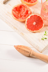 Healthy summer drink grapefruit lemonade with thyme in glasses with ice on a wooden surface.