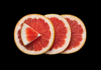 Juicy sliced grapefruit isolated on black background close up. Flat lay. Bright red grapefruit citrus fruit cut in half. Macro, top view. Minimalistic picture.