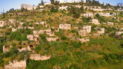 Fototapeta na wymiar Flying over abandoned Palestinian Lifta Village Aerial view of Lifta abandoned Palestinian Village with the main entrance to Jerusalem in the background 