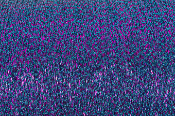 background of multicolored lurex thread in pink and turquoise on a cone