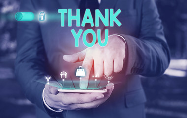 Conceptual hand writing showing Thank You. Concept meaning a polite expression used when acknowledging a gift or service Male wear formal suit presenting presentation smart device