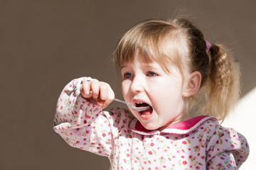 cute little girl with spoon in open mouth