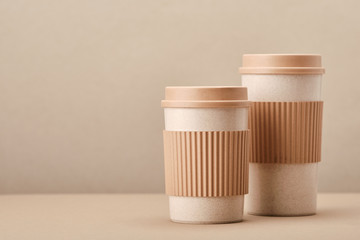 Two Eco Coffee Cup Isolated on Beige Background