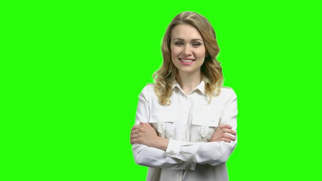 Charming office lady on green screen background. Pretty smiling woman in white shirt looking at camera with crossed arms.