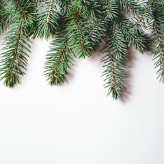 Fir branches on white wooden background. Christmas wallpaper. Flat lay, copy space.