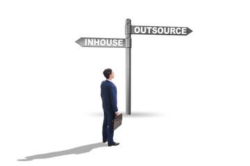 Businessman at crossroads deciding between outsourcing and inhou