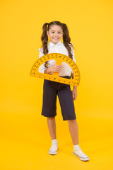 Mathematics matters. Small child holding protractor for mathematics lesson on yellow background....