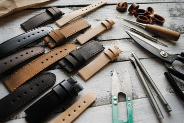 Metal tools and watch straps are on the table.