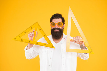 Man math lesson. Smart student. College university education. Bearded nerd with triangle. Exploring properties. Student using measuring instrument. Engineering architecture faculty student
