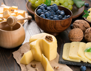 cheese, blueberries, and honey on a wooden background