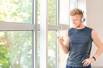 Sporty young man listening to music in gym